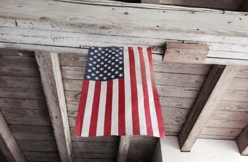 United States flag hanging from wooden rafters